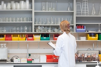 Serious female scientist writing on her clipboard in a laboratory-2